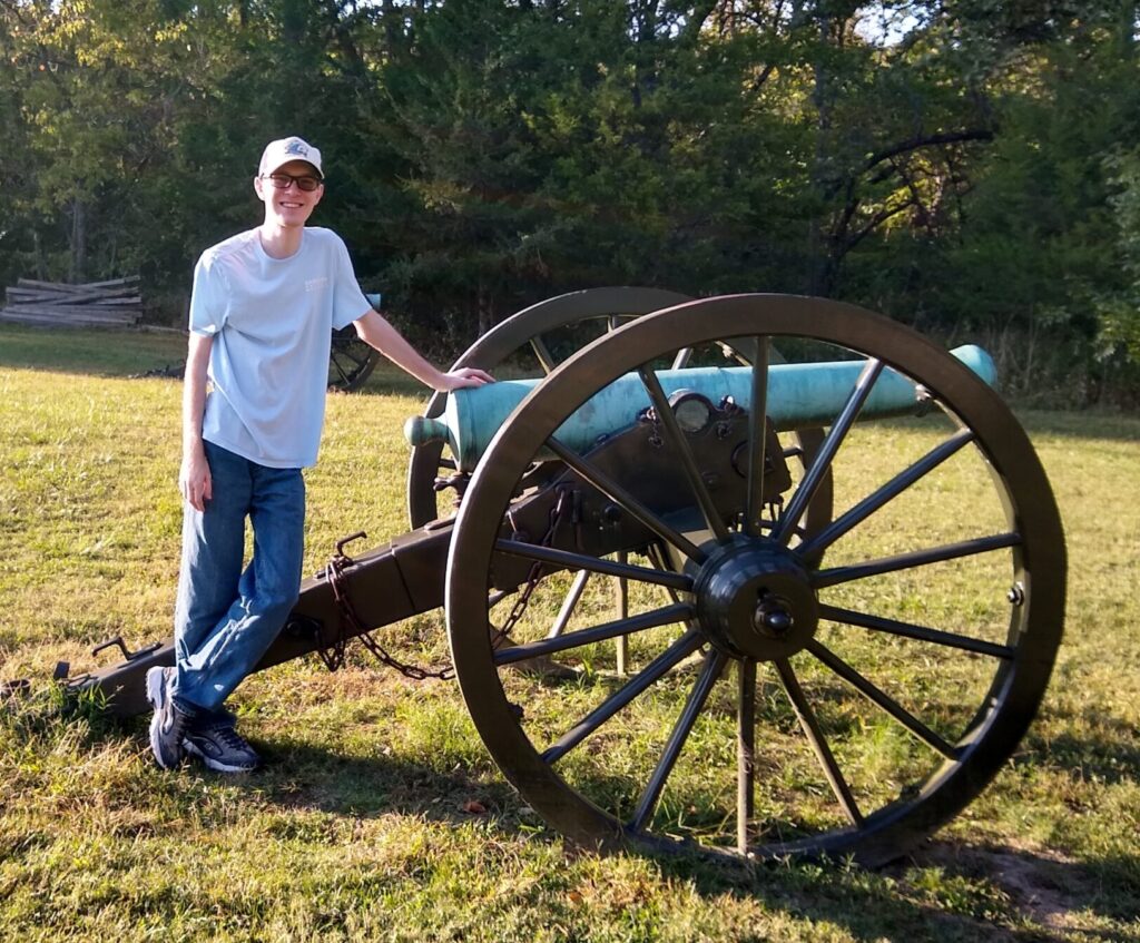 Justin Wilson standing at the back of a civil war cannon.